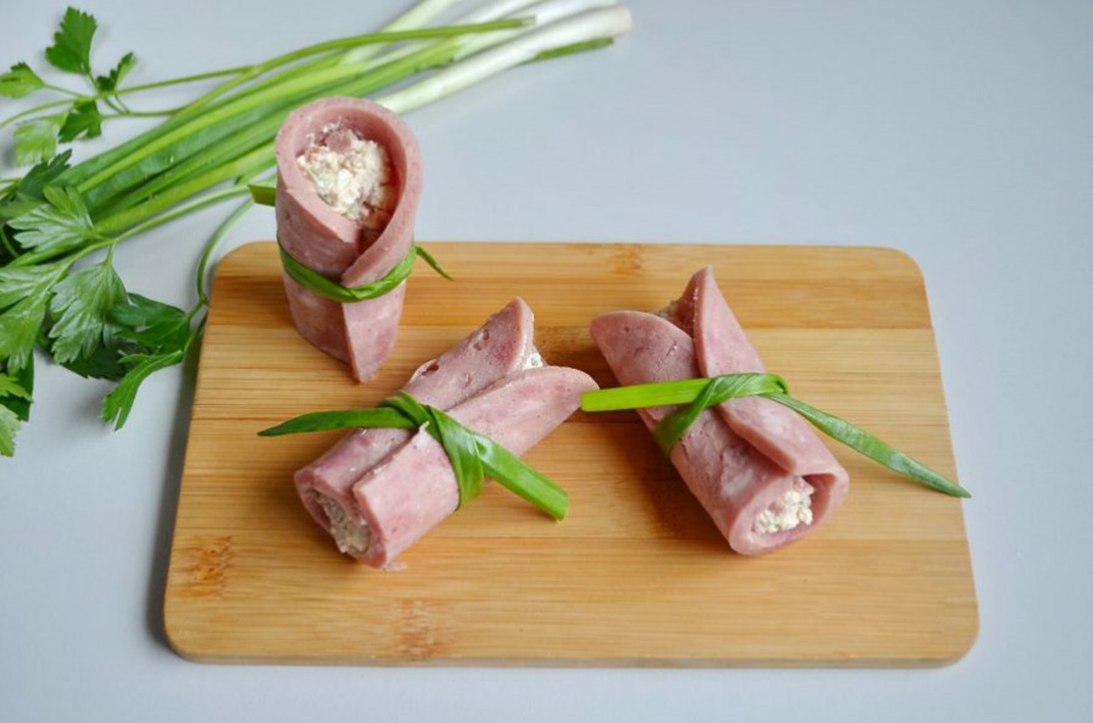 Coloca un poco de verdura sobre cada rebanada de jamón y forma rollitos. Acompáñalo con galletas integrales, una fruta mediana y agua natural.