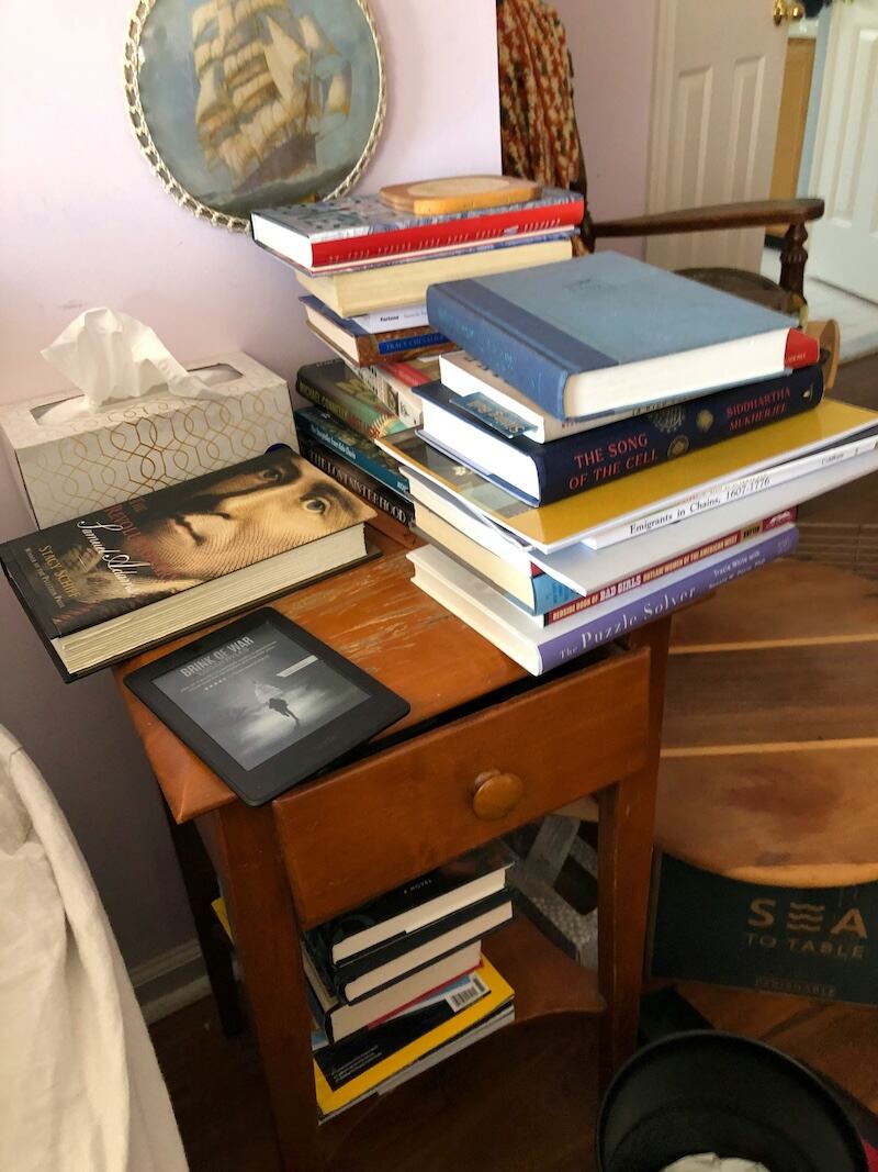 demasiados libros y desorden en la habitacion junto a la cama