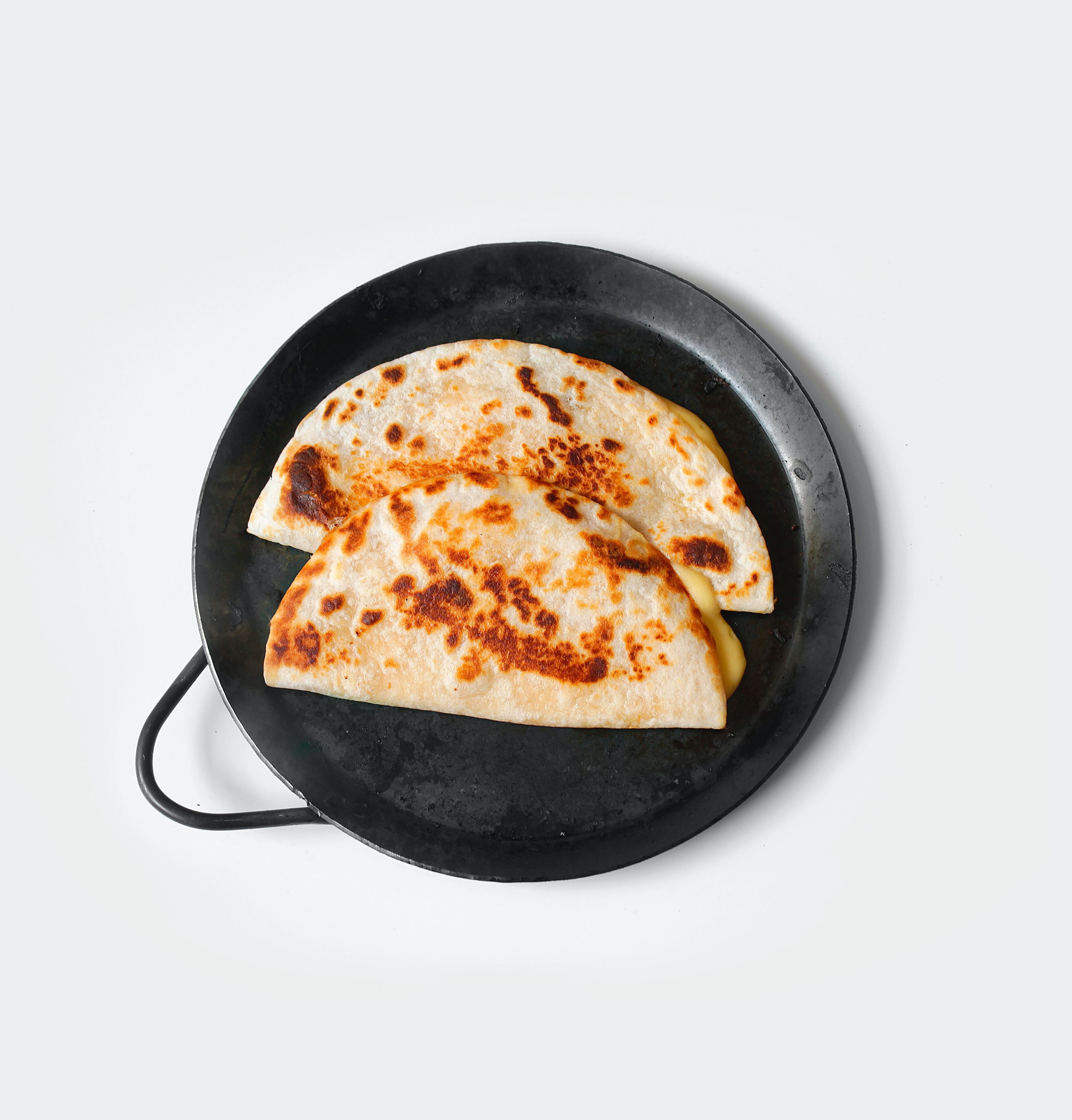 Sincronizadas. Necesitas 2 tortillas,  2 rebanadas de jamón de pavo, queso panela. En el sartén, coloca una tortilla y sobre el jamón y el queso panela.