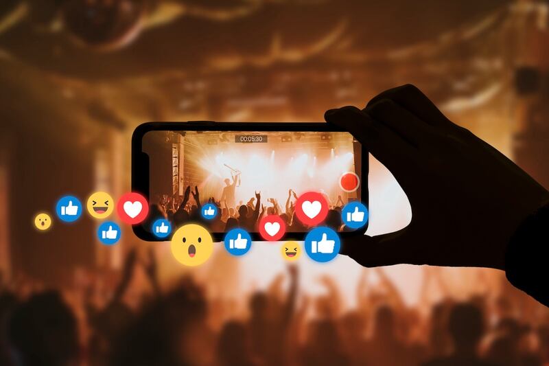 persona grabando concierto con su celular, emojis, like, me gusta, me encanta, me enrisa